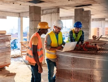 Engineer, architect and business man working on the engineering project at construction site. House building concept. Photo of young male architect engineer using laptop computer.