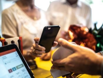 Senior woman paying by mobile in a store