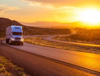 18-wheeler tractor-trailer truck and US highway 70 at sunset near Tularosa, New Mexico