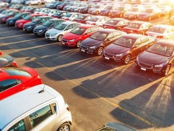 Dealer New Cars Stock. Colorful Brand New Compact Vehicles For Sale Awaiting on the Dealer Parking Lot. Car Market Business Concept.