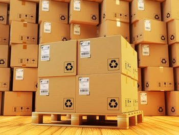 Cardboard boxes on pallet and stack of parcels behind it on wooden floor in the retail store building